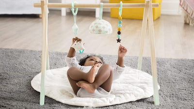 a baby playing in Wooden Play Gym